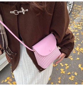 Pink houndstooth pattern crossbody bag worn by a model in an autumn outdoor setting