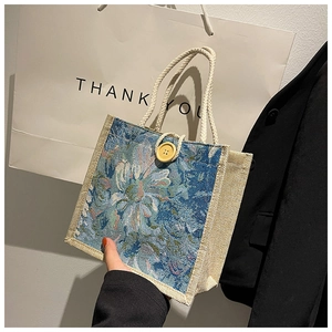 Close-up of linen tote bag featuring vintage blue floral pattern and rope handles