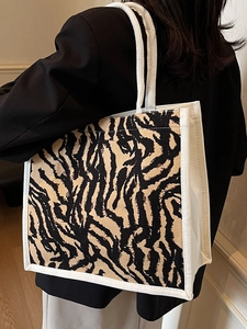 Detailed side view of a large zebra pattern canvas tote bag with woven cotton handles