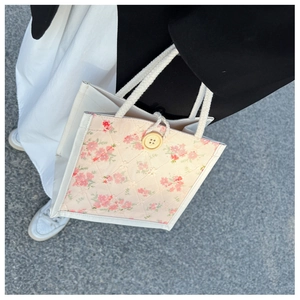 Detail of floral tote bag showing quilted texture and sturdy white cotton rope handle