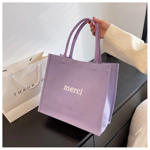 Dettaglio della borsa tote in tela viola con stampa merci bianca e grande capacità