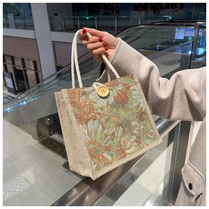 Close-up of tapestry floral linen tote bag with large wooden button and rope handles