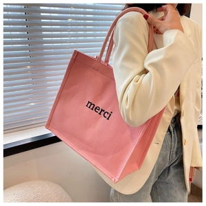 Borsa tote in tela rosa con scritta merci nera e manici spessi in corda intrecciata