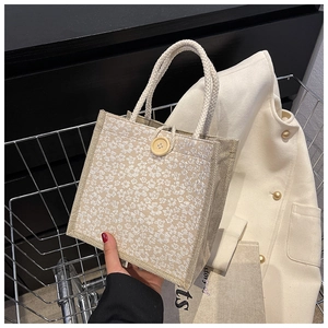 Detail of canvas tote bag featuring 3D floral patterns and a large wooden button