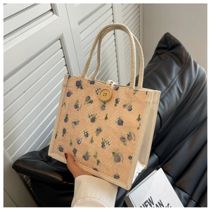 Detailed close-up of pink floral lace lunch bag with yellow wooden button and cotton rope