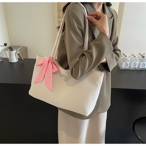 Detail der beige Tote-Tasche mit rosa karierter Schleife und kreisförmiger B-Logo-Schnalle
