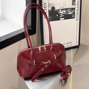 Retro burgundy shell handbag with glossy finish and gold metal accents on stylish metal stand