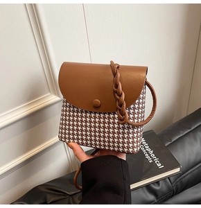Detailed shot of brown leather and houndstooth crossbody bag with retro buckle