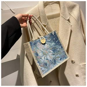 Close-up of blue floral jacquard linen tote bag featuring a round wooden button closure