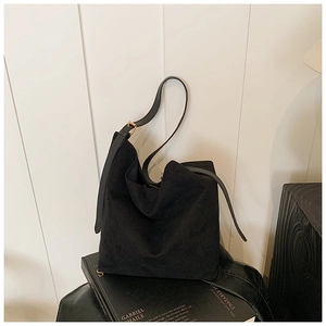 Détail du sac cabas noir minimaliste avec texture mate et boucle en métal doré carrée