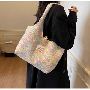 Detail of colorful knit tote bag featuring pastel pink and blue textures with brand label
