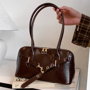 Deep brown glossy shell handbag with gold hardware and top handle for women