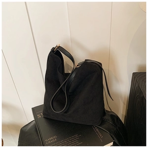 Détail du sac hobo en daim noir avec bandoulière réglable et boucle en métal doré