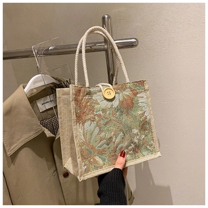 Detail of floral jacquard linen lunch bag with woven handles and large wooden button closure