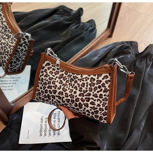 Dettaglio borsa a tracolla leopardata con bordo in ecopelle marrone e finiture argentate