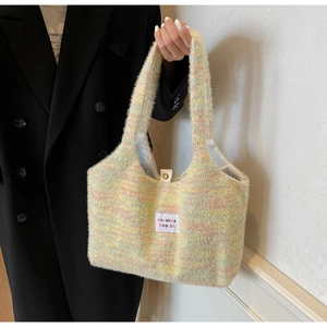 Detail of colorful fuzzy knit tote bag with metal snap closure and brand label detail