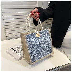 Detail of linen tote bag with blue floral patterns and white woven rope handles