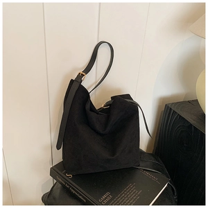 Détail du sac cabas en daim noir avec bandoulière réglable et boucle en métal doré