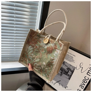 Close-up of linen bag with floral tapestry pattern, rope handle, and wooden button