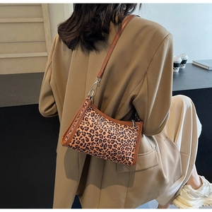Dettaglio della borsa a spalla leopardata con rifiniture in pelle marrone su modella