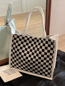 Off-white canvas tote bag with black checkerboard pattern and rope handles