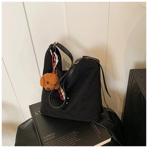 Détail du sac cabas en daim noir avec pendentif chiot et foulard à carreaux chic