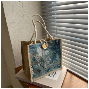 Detail of vintage linen handbag with floral jacquard fabric and thick cotton rope handles