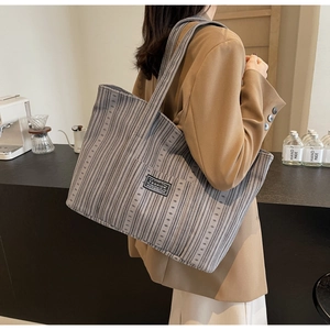 Vue détaillée du sac cabas gris rayé avec étiquette en tissu noir style tendance