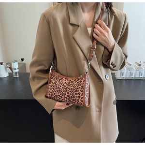 Dettaglio della borsa a tracolla leopardata con finiture in pelle marrone e tracolla regolabile