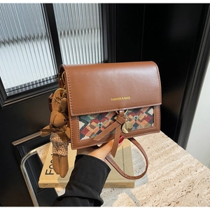 Detail of vintage crossbody bag with flap, geometric pattern, and rabbit charm accessory