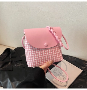 Close-up of pink houndstooth weave fabric and braided shoulder strap on a bucket bag