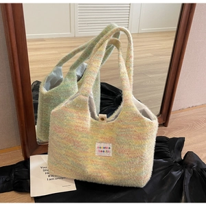 Close-up of pastel multicolor knit tote bag featuring soft fuzzy texture and woven brand label