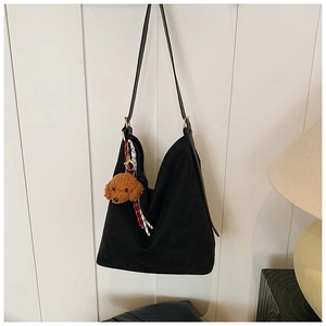 Vue détaillée du sac cabas noir avec pendentif ours en peluche et décoration de foulard rayé