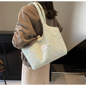 Close-up of soft fuzzy knit tote bag with colorful mohair texture and brand label