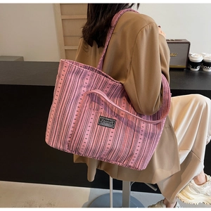 Vue détaillée du sac cabas en toile à rayures roses et violettes avec étiquette mode