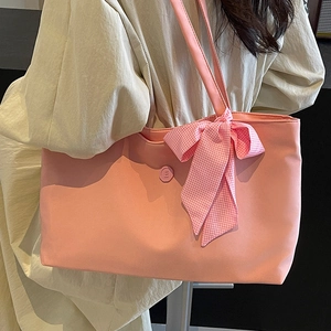 Rosa Tragetasche mit karierter Schleife und geprägtem E-Logo am Modell präsentiert