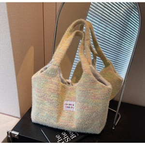 Close-up of pastel multicolor fuzzy knit tote bag with metallic snap and textile label