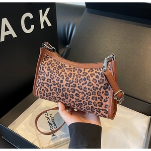 Dettaglio della borsa sottobraccio leopardata con finiture in pelle marrone e fibbia