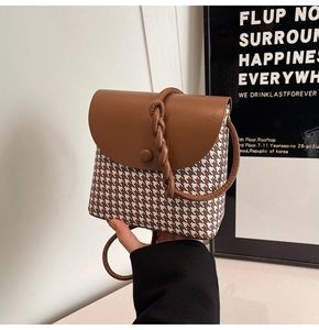 Detail of retro houndstooth crossbody bag with brown leather flap and braided strap