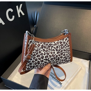Dettaglio borsa a spalla leopardata con rifiniture in pelle marrone e fibbia in metallo