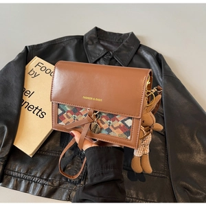 Detailed view of brown PU leather crossbody bag with jacquard fabric and rabbit charm