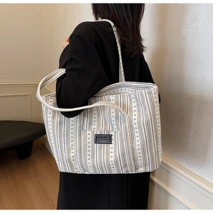 Détail d'un grand sac cabas en toile à rayures avec étiquette Fashion et longues anses