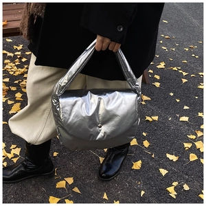 Metallic silver puffer cloud bag shown against autumn leaves for trendy outdoor style