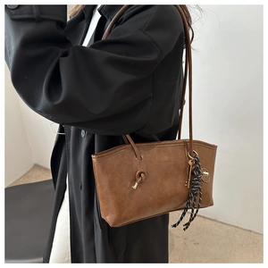 Detail of brown PU leather tote bag with knot strap, silk scarf and key pendant