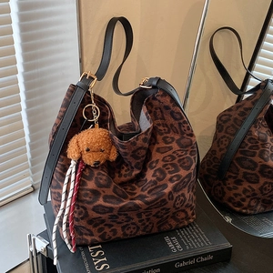Sac cabas léopard chic avec breloque nounours et reflet élégant dans le miroir