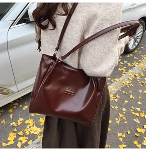 Detailed view of deep brown tote bag with vintage texture and long shoulder straps
