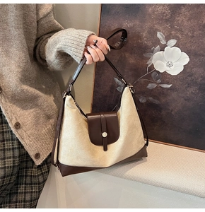 Detail of retro canvas tote with brown leather patchwork and round metal buckle