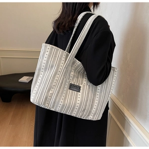 Gros plan d'un grand sac cabas en toile rayé noir et blanc avec écusson logo tendance
