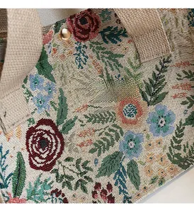 Detail of floral woven fabric with red roses and durable beige canvas shoulder strap