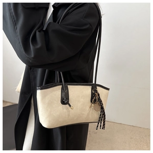 Detail of a contrast minimalist tote bag featuring a tennis racket charm and tassel